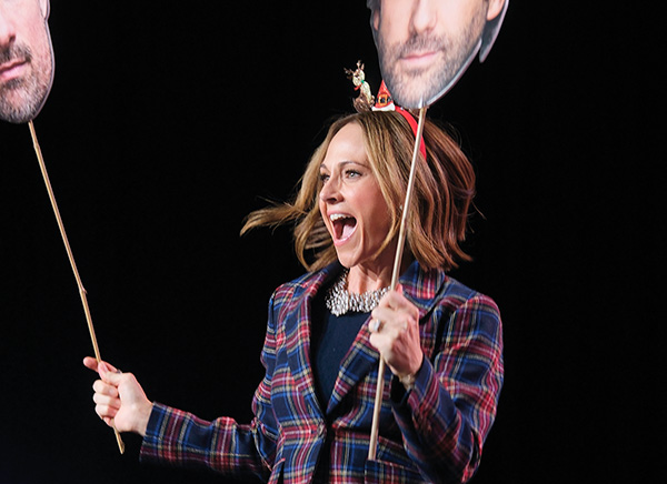 120625_MT_ReindeerGames_096_HSLSite_crop Action shot from a Reindeer Games event, woman holding two large printed headshots on sticks